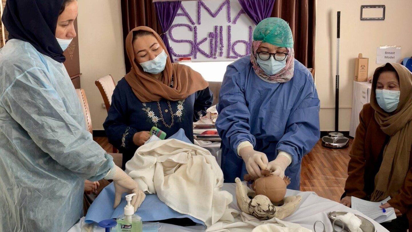 Midwives practising with a mannequin.